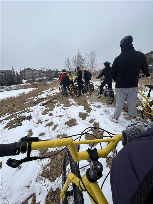 students get ready to roll with a yellow bike in foreground. 