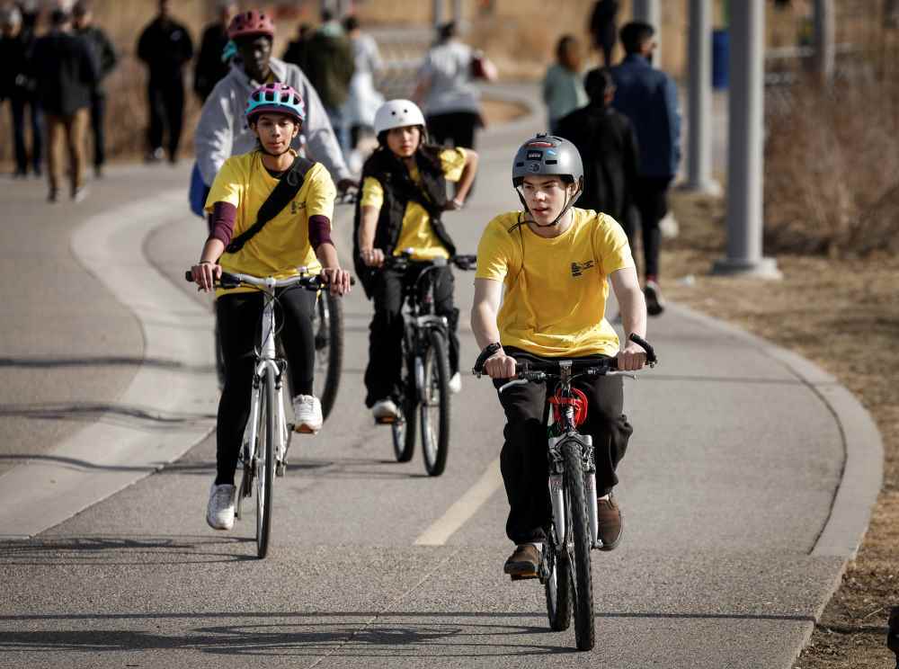 Youth wearing helmets and riding their bicycles in downtown Calgary. (Photo credit: Youth en Route)