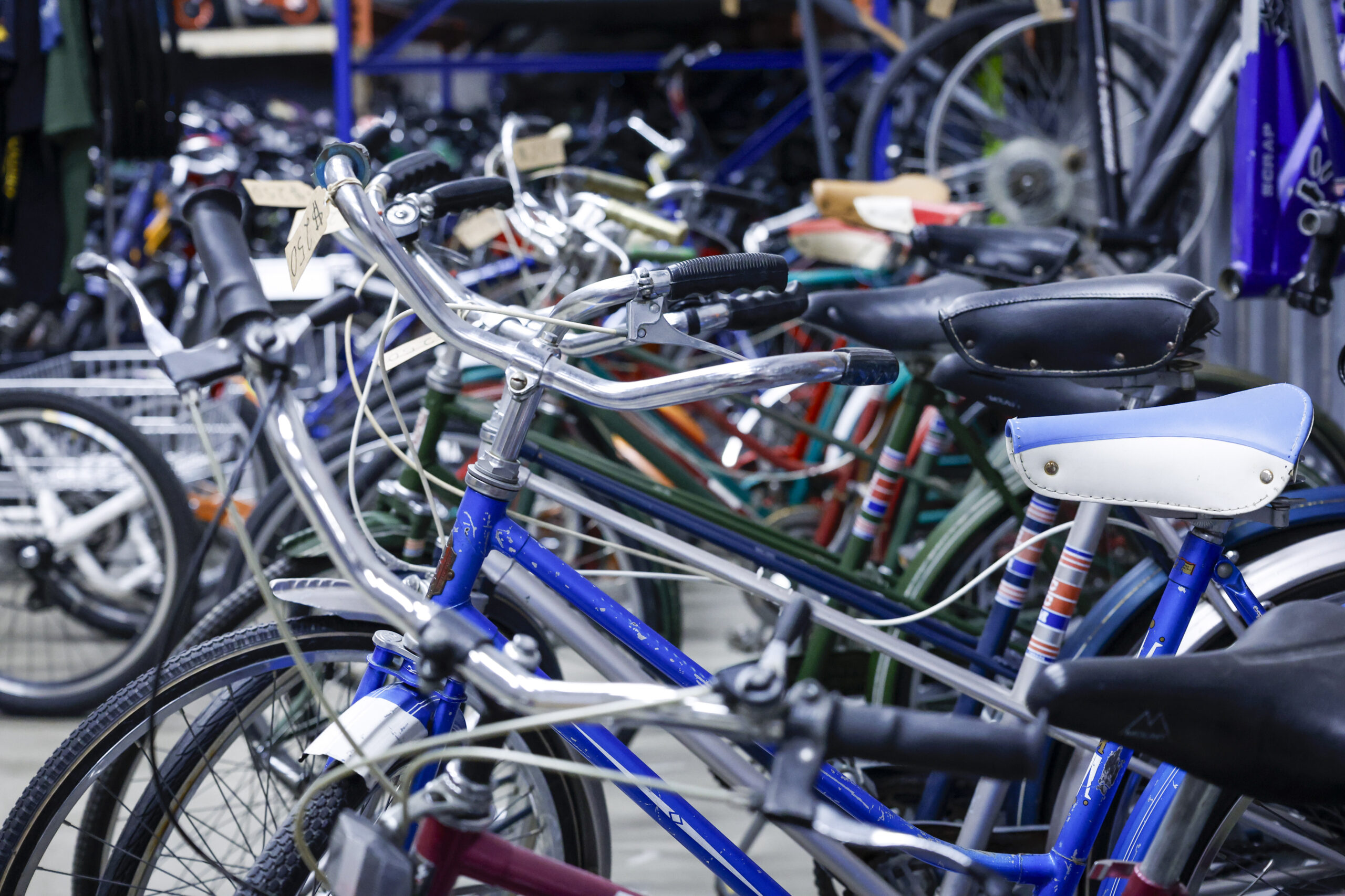 old bikes are lined up in a storage area