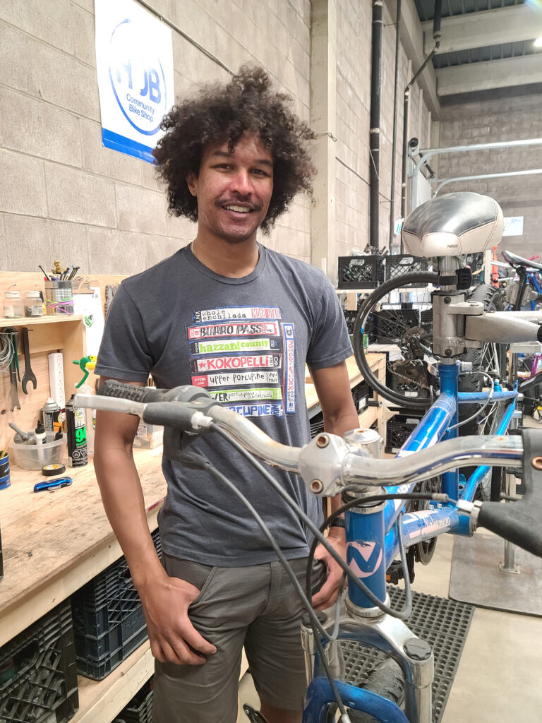One of our new summer mechanics, Bon, working on repairing a bike for the Kids Bike Trade Up